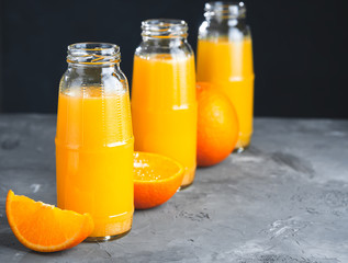 Fresh Orange Juice, Glass Bottle of Juice,Wooden Tray,Grey Table, Dark Background.