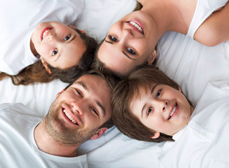 Family of four lying on bed
