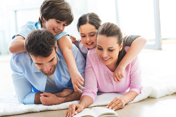 Happy family reading book together 