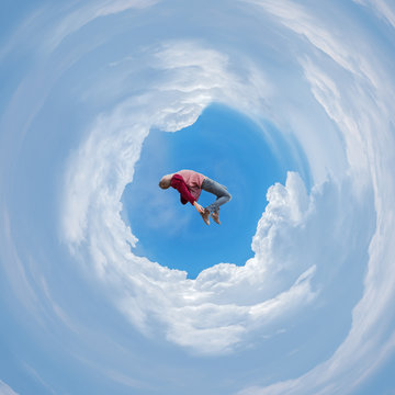 Photo manipulation with spherical panorama of a man free falling between clouds..