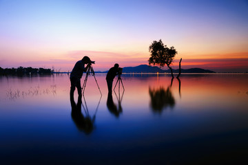 Photographers, silhouette of two photographers and sunset .