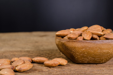 almond from wooden bowl on wooden board