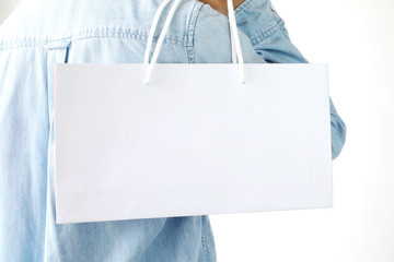 Hand holding white shopping bag isolated on white background with copy space for text, template, business concept