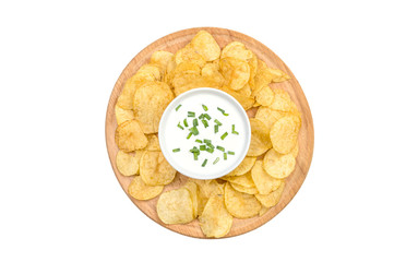 Potato chips and sour cream on the round wooden board. Isolated on white. Top view.