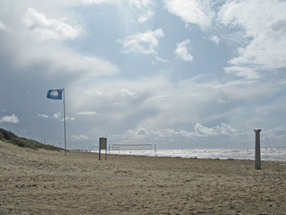 Sandy blue flag beach at Skrea Strand on a windy and sunny day with dark clouds in Falkenberg, Sweden.