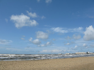 Sandy beach at Skrea Strand on a windy and sunny day with dark clouds in Falkenberg, Sweden.