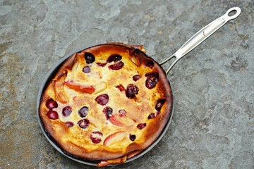 Peach and cherry Dutch pancake clafoutis in a pan 