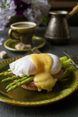 Breakfast. Eggs Benedict with asparagus and coffee.
