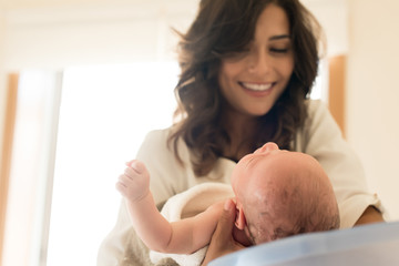 Mother washing baby in bath tub