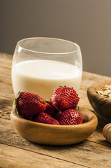 Fresh strawberry in wooden bowl on table.