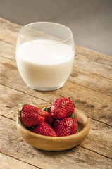 Fresh strawberry in wooden bowl on table.
