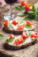 Crostini appetizers with cherry tomatoes, and cheese