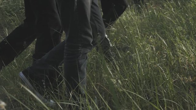 group of men in black clothes go into the distance into the forest