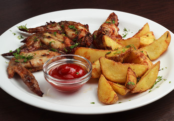 Chicken wings with fries french and spicy sauce on a plate