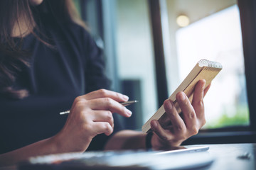 A business woman working , holding notebook and using calculator in office