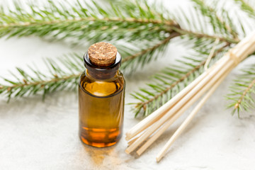 Bottles of essential oil and fir branches for aromatherapy and spa on white table background
