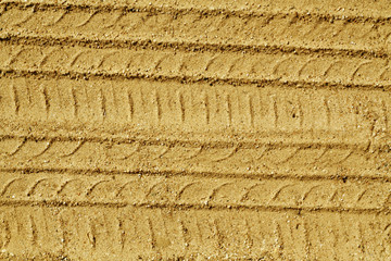Car tires tracks on sandy road.
