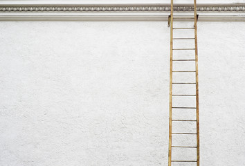 White stucco wall of historical building with metal fire escape ladder