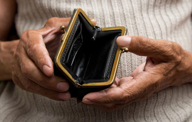 An elderly man holds an empty purse. The concept of poverty in retirement .