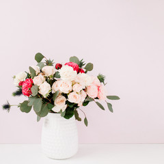Beautiful flowers bouquet in flowerpot in front of pale pastel pink wall. Floral lifestyle composition.