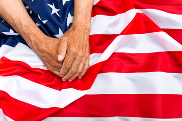 The older man put his hands on the us flag. The concept of caring for pensioners.