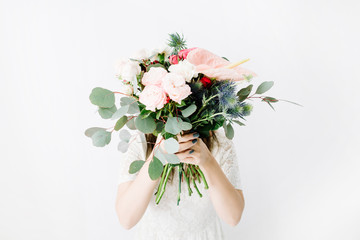 Pretty woman with beautiful flowers bouquet at white wall. Lifestyle composition.