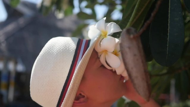 guy enjoying the scent of flowering tropical trees.Plumeria