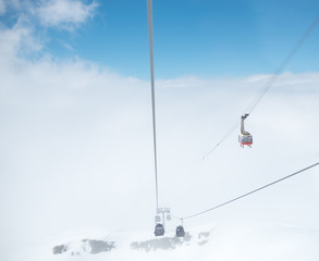 .Cabin of ropeway in mountains among clouds in the sky