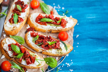 Bruschetta with cream cheese, pesto, fresh basil and sun dried tomatoes