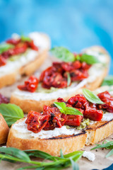 Bruschetta with cream cheese, pesto, fresh basil and sun dried tomatoes
