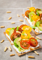 Сrisp bread toast  with cream cheese, fresh avocado, cherry tomatoes and pine nuts