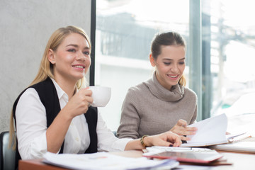 Young woman working together in modern place. Business people takling in modern office. Greeting deal concept