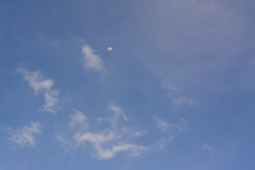 A half moon on clouds and blue sky background.