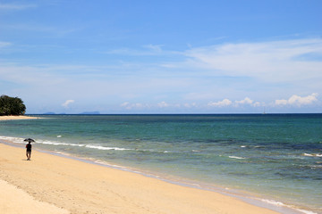 Travel to Island Koh Lanta, Thailand. The view on the sand beach with blue sea on a sunny day.