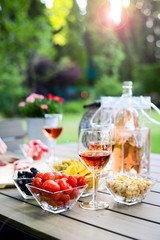 holiday summer brunch party table outdoor in a house backyard with appetizer, glass of rosé wine, fresh drink and organic vegetables © W PRODUCTION
