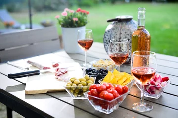 Küchenrückwand glas motiv Feiertags-Sommerbrunch-Partytisch im Freien in einem Hausgarten mit Vorspeise, Glas Roséwein, frischem Getränk und Bio-Gemüse © W PRODUCTION