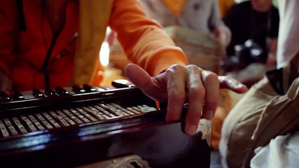 The performance of the kirtan of the hare Krishna in the Krishna temple on the ancient classical instruments. Big game plan the harmonium.
