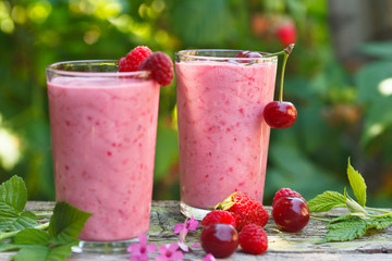 Healthy homemade raspberry, strawberry and sour cherriy smoothies in glasses. outdoor image.