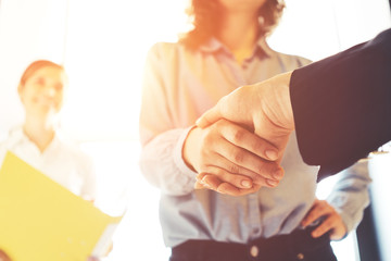 Business people shaking hands. Women finishing successful meeting. Three persons. Intentional sun...