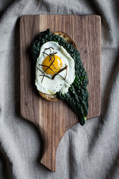 Fried egg on kale and toast, overhead view, vignette 