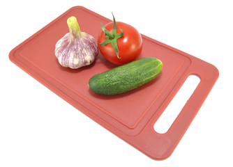 Огурец чеснок и помидор на разделочной доске