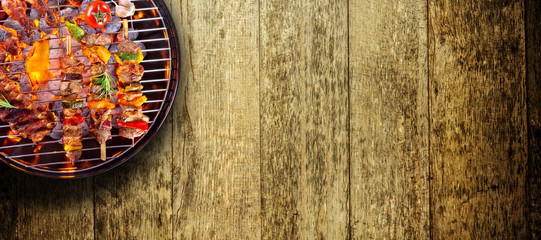 Top view of fresh meat and vegetable on grill placed on wooden floor