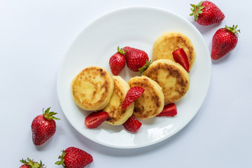 Delicious curd fritters with strawberry on a white plate
