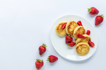 Delicious curd fritters with strawberry on a white plate