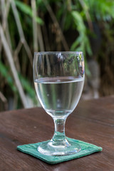 Glass of water on a wooden table in a restaurant. Bali island.