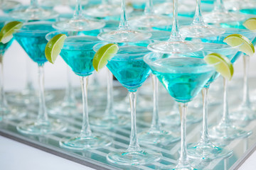 Background of glasses with cocktails and lime
