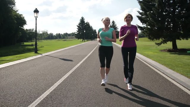 Jogging senior women running parkway in sportswear