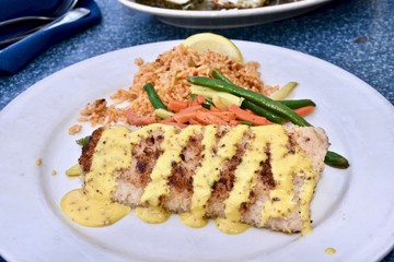Grilled mahi-mahi drizzled with creamy sauce served with a side of rice and mixed vegetables