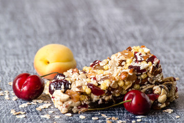 Useful snack. Bars of muesli with cereals and fruits on a wooden background.
