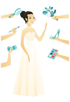 Young asian bride in a white dress and many hands around her that hold photo camera, brush, comb, bouquet of flowers, shoe, eye shadow
